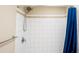 A tiled shower with a blue curtain and white tile walls at 13116 Sheridan Dr, Hudson, FL 34667