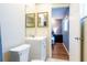 Bathroom with vanity and mirrors, toilet, and doorway to bedroom with wood floors at 13116 Sheridan Dr, Hudson, FL 34667