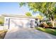 Charming single-story home with a two-car garage, manicured lawn, and an American flag at 13116 Sheridan Dr, Hudson, FL 34667