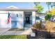 Inviting front entrance with decorative gate, charming landscape, and American flag at 13116 Sheridan Dr, Hudson, FL 34667