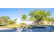 Charming front exterior with well-manicured lawn, mature trees, and a two-car garage at 13116 Sheridan Dr, Hudson, FL 34667