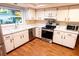 Bright kitchen with stainless steel appliances, lots of cabinet space, and wood flooring at 13116 Sheridan Dr, Hudson, FL 34667