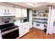 Walk-in pantry filled with canned goods and spices adjacent to kitchen with wood flooring at 13116 Sheridan Dr, Hudson, FL 34667