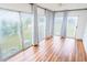 Bright sunroom with ceiling fan, wood floors, and large sliding glass doors and curtains at 13116 Sheridan Dr, Hudson, FL 34667