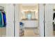 The bathroom boasts a dual sink vanity with granite countertops, framed by white doors and decor at 13823 Messina Loop # 204, Bradenton, FL 34211