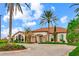 Beautiful clubhouse showcasing stone accents, a terracotta tile roof, and lush landscaping against a bright blue sky at 13823 Messina Loop # 204, Bradenton, FL 34211