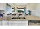 Modern kitchen showcasing granite countertops, stainless steel appliances, and an open view to the living area at 13823 Messina Loop # 204, Bradenton, FL 34211