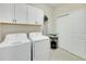 Functional laundry room with modern washer and dryer, cabinet storage, and closet space at 13823 Messina Loop # 204, Bradenton, FL 34211