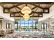 Bright meeting room with large windows offering scenic views, wood beam ceilings, and ample seating for large events at 13823 Messina Loop # 204, Bradenton, FL 34211