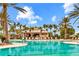 A luxurious pool area with palm trees, a bar, and comfortable lounge seating for relaxation at 13823 Messina Loop # 204, Bradenton, FL 34211