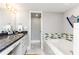 Modern bathroom with a soaking tub, marble countertops, and decorative tile accents at 1390 Gulf Blvd # Ph 2, Clearwater Beach, FL 33767