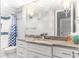 Bathroom with chevron shower curtain, granite countertop, white cabinets, and contemporary fixtures at 1390 Gulf Blvd # Ph 2, Clearwater Beach, FL 33767