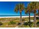 Beautiful beach view with white sand, palm trees, and clear blue water at 1390 Gulf Blvd # Ph 2, Clearwater Beach, FL 33767
