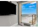 View from bed in bedroom with mounted Samsung TV and balcony overlooking the beach at 1390 Gulf Blvd # Ph 2, Clearwater Beach, FL 33767