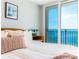 Charming bedroom with a comfy bed, bedside table, and balcony overlooking the ocean at 1390 Gulf Blvd # Ph 2, Clearwater Beach, FL 33767