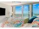 Cozy bedroom with ocean view, featuring a private balcony, colorful bedding and modern desk and lamp at 1390 Gulf Blvd # Ph 2, Clearwater Beach, FL 33767