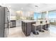 Open-concept kitchen with stainless steel appliances, tile backsplash, and island with bar stools at 1390 Gulf Blvd # Ph 2, Clearwater Beach, FL 33767