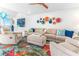 Bright living room with plush seating, colorful rug, and unique wall decor at 1390 Gulf Blvd # Ph 2, Clearwater Beach, FL 33767