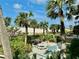 View of an outdoor space with a picnic table, benches, palm trees, plants, and a grill overlooking the beach at 1390 Gulf Blvd # Ph 2, Clearwater Beach, FL 33767