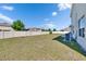 Large, grassy backyard enclosed by a white fence, offering privacy and space for outdoor activities at 14153 Arbor Pines Dr, Riverview, FL 33579