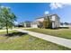 Two-story home featuring a landscaped yard, two-car garage and driveway on a bright day at 14153 Arbor Pines Dr, Riverview, FL 33579