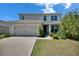 Charming two-story home featuring a well-maintained lawn, a two car garage, and inviting front porch at 14153 Arbor Pines Dr, Riverview, FL 33579