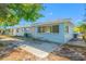 Backyard view of the blue home with a patio area and lush greenery at 1431 Kings Hwy, Clearwater, FL 33755