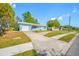 Charming blue home featuring a well-manicured lawn and a long driveway at 1431 Kings Hwy, Clearwater, FL 33755