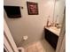 Cozy bathroom with dark wood cabinets, granite countertops, and a framed floral wall print at 16313 Bridgecrossing Dr, Lithia, FL 33547