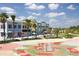 Vibrant community with colorful buildings, palm trees, and a playful splash pad for Gathering fun at 16313 Bridgecrossing Dr, Lithia, FL 33547