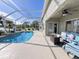 Enjoy the view from the screened-in lanai with pool and outdoor seating area at 16313 Bridgecrossing Dr, Lithia, FL 33547