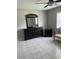 A bedroom featuring a matching dark dresser with a mirror and bedside table, with ceiling fan at 1660 Caledonia Dr, Palm Harbor, FL 34684