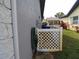 Exterior side view with hose, A/C, trash can, and partial view of house and white fence at 1660 Caledonia Dr, Palm Harbor, FL 34684