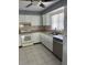 Bright kitchen featuring white cabinets, tile backsplash, and stainless steel dishwasher at 1660 Caledonia Dr, Palm Harbor, FL 34684