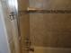 Shower featuring tan tiling with decorative mosaic border at 1660 Caledonia Dr, Palm Harbor, FL 34684
