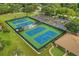 Aerial view of community tennis courts, surrounded by lush greenery at 1660 Caledonia Dr, Palm Harbor, FL 34684