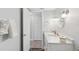Bathroom features a white vanity, round mirror, and access to storage at 17035 Gulf Blvd # 202, North Redington Beach, FL 33708