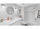 Bright bathroom features a shower-tub combination and a large, round mirror at 17035 Gulf Blvd # 202, North Redington Beach, FL 33708