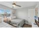 Bedroom with two twin beds, ceiling fan, and natural light from a large window at 17035 Gulf Blvd # 202, North Redington Beach, FL 33708