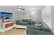 Comfortable living room with a large sectional sofa, wall-mounted TV, and bright natural light at 17035 Gulf Blvd # 202, North Redington Beach, FL 33708