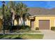 Charming townhome featuring a well-maintained lawn, palm trees, and a single-car garage at 1706 Trailwater St, Ruskin, FL 33570