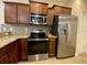 Well-equipped kitchen features granite countertops, stainless steel appliances and brown cabinets at 1706 Trailwater St, Ruskin, FL 33570