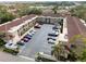 Aerial view of condos with a red tile roof, palm trees, and parking lot at 19029 Us Highway 19 N # 2-12, Clearwater, FL 33764