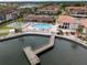 Aerial view featuring a community pool, tennis courts, and waterway at 19029 Us Highway 19 N # 2-12, Clearwater, FL 33764