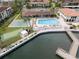 Aerial view of the community pool, shuffleboard, and canal with dock at 19029 Us Highway 19 N # 2-12, Clearwater, FL 33764