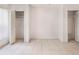 Neutral bedroom featuring tile flooring, and two large closets with louvered doors at 19029 Us Highway 19 N # 2-12, Clearwater, FL 33764