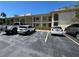 Apartment building featuring a parking lot with multiple parked vehicles on a sunny day at 19029 Us Highway 19 N # 2-12, Clearwater, FL 33764
