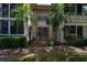 Exterior facade of condo building with patio and tropical landscaping at 19029 Us Highway 19 N # 2-12, Clearwater, FL 33764