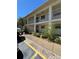 This exterior shot showcases a two-story apartment building with private balconies and lush landscaping at 19029 Us Highway 19 N # 2-12, Clearwater, FL 33764