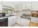 Kitchen showcasing white cabinetry, tile floors, and stainless steel appliances at 19029 Us Highway 19 N # 2-12, Clearwater, FL 33764
